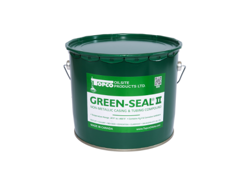A green bucket of paint on top of a table.